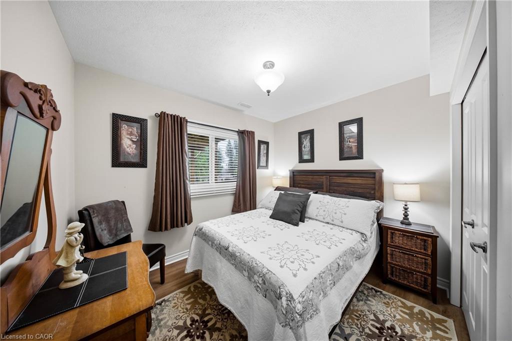 Bedroom with a wooden bed, floral bedding, brown curtains, and an ornate dresser mirror.