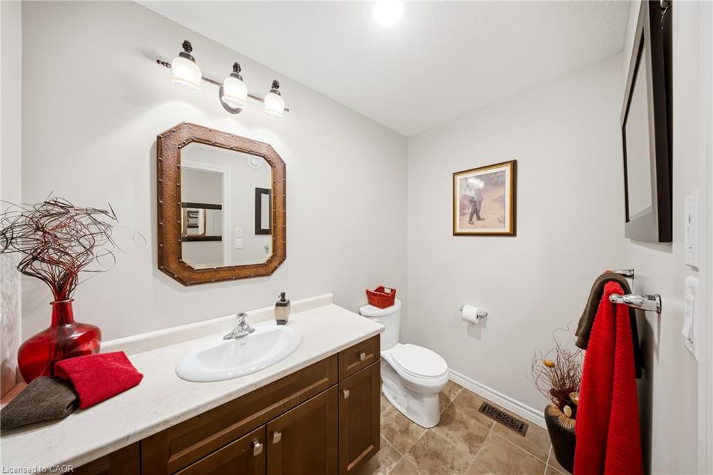 Bathroom with a long wood vanity, white countertop, and octagonal framed mirror.