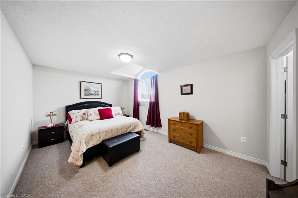 Bedroom with floral bedding, red accent pillows, and a wooden dresser.