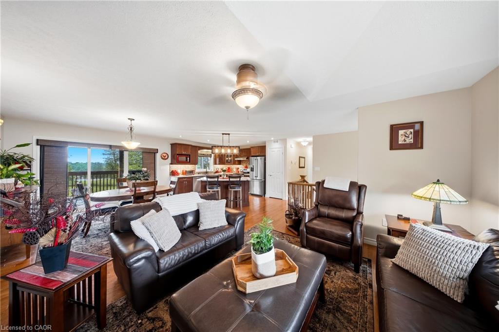 Living room with dark leather seating, a patterned rug, and an open kitchen beyond.