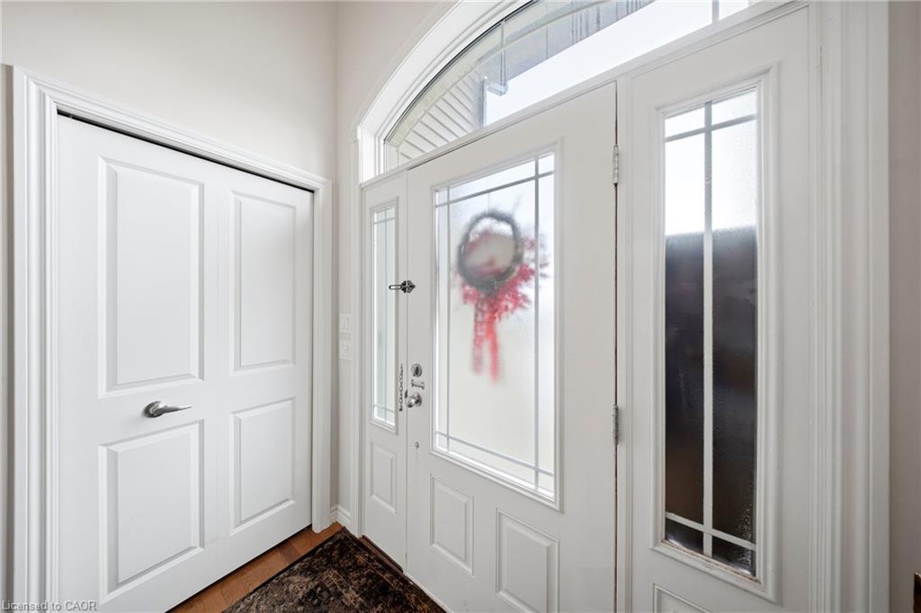 Front entry foyer with a white glass-panel door, arched transom, and red wreath.
