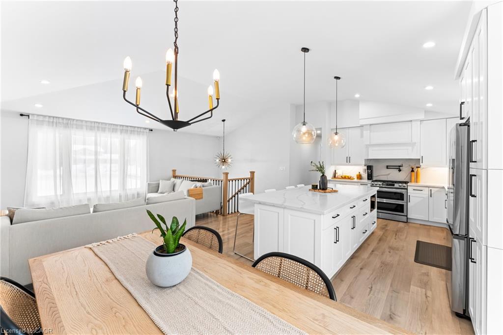 Open-plan kitchen and living area with a large island, wood floors, and dining table.