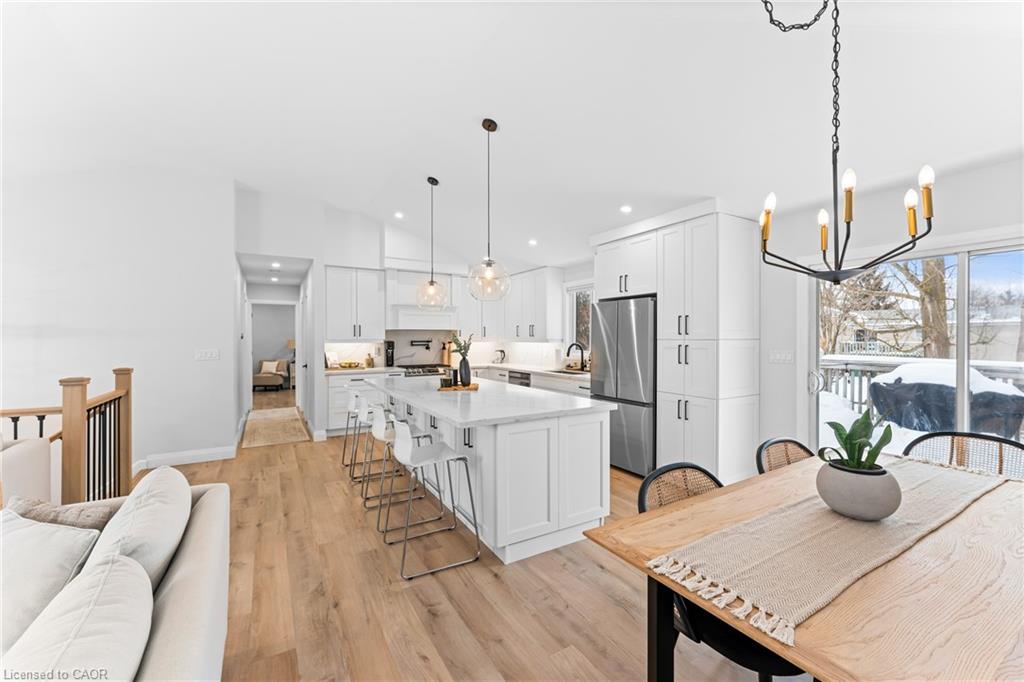Open-concept kitchen with a large island, white cabinetry, and sliding doors to a snowy deck.