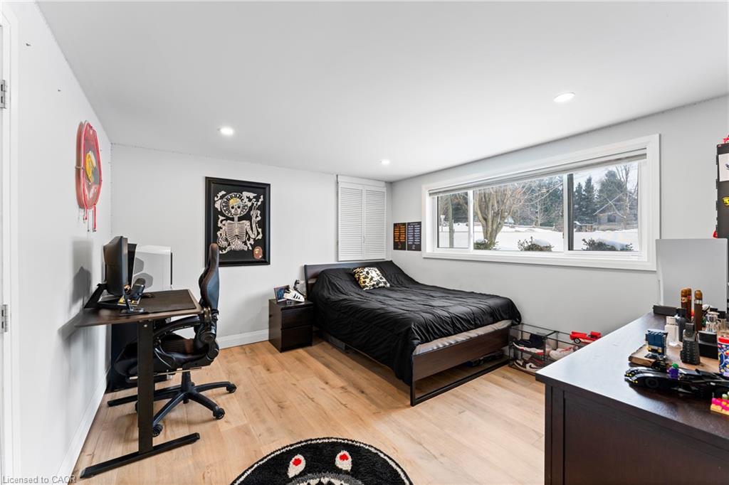 Bedroom with a black bed, computer desk, and wide window overlooking snow.