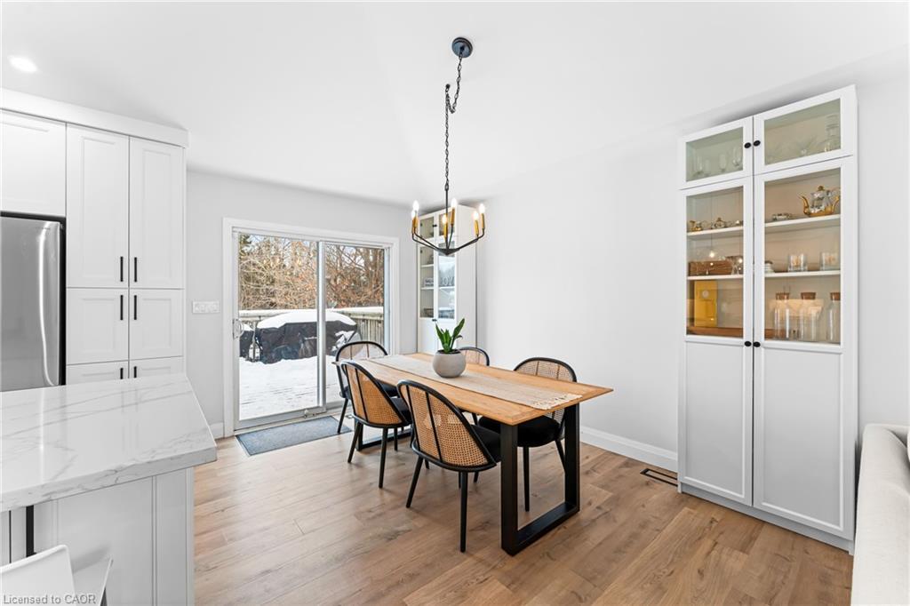 Dining area with a wooden table, white display cabinets, and sliding doors to a snowy deck.