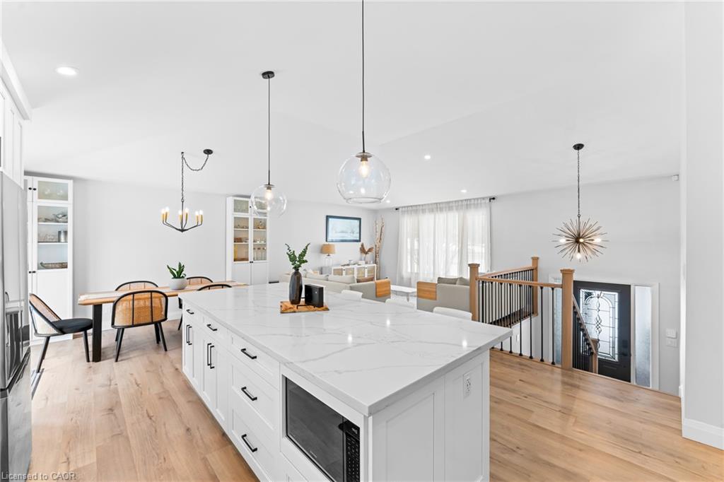 Open-concept kitchen with a large white island overlooking the dining and living areas.