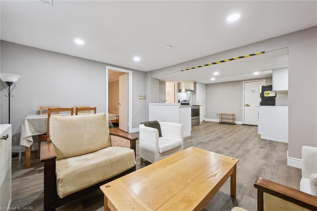 Open-concept living and dining area with wood-look floors and the kitchen beyond.