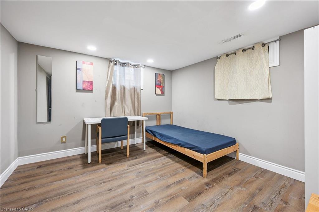 Bedroom with a single bed, desk, and wood-look flooring.