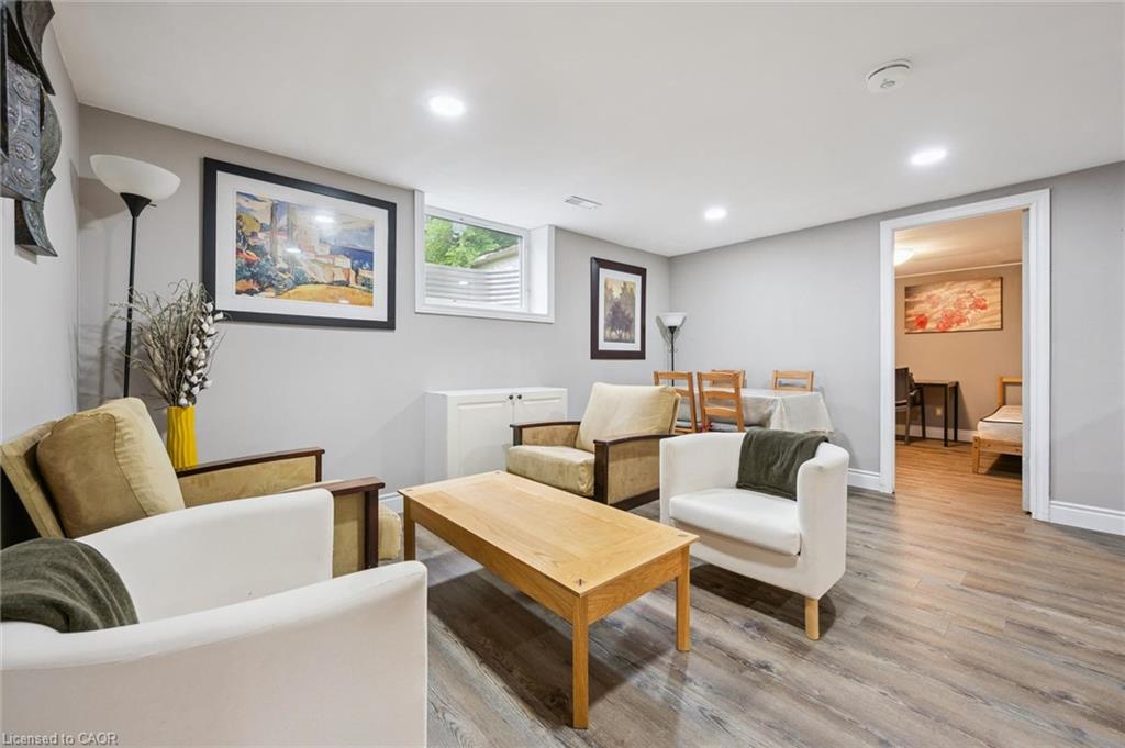 Living room with white and tan armchairs, a wood coffee table, and an adjoining dining area.