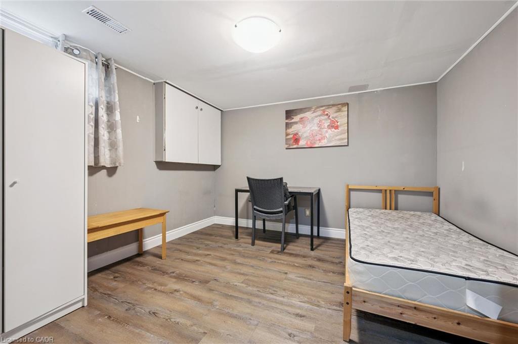 Bedroom with a single bed, desk, chair, and wall-mounted storage cabinets.
