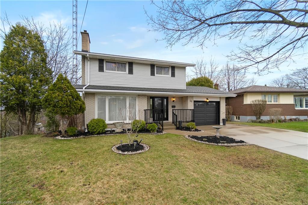 Two-story house with a covered entry, attached garage, and landscaped front lawn.
