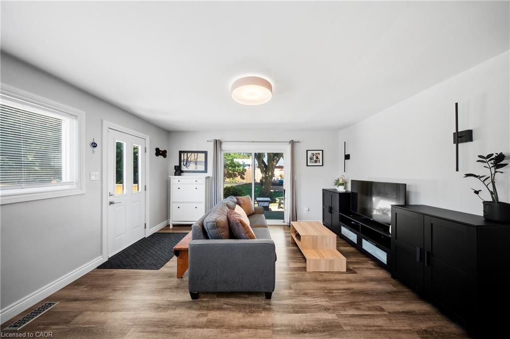 Living room with a gray sofa, black media cabinets, and sliding glass doors to the backyard.