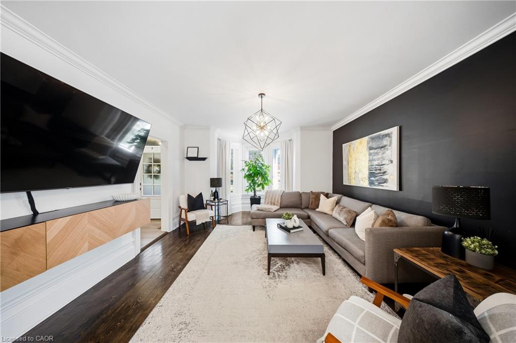 Living room with a gray sectional, charcoal accent wall, and large television.