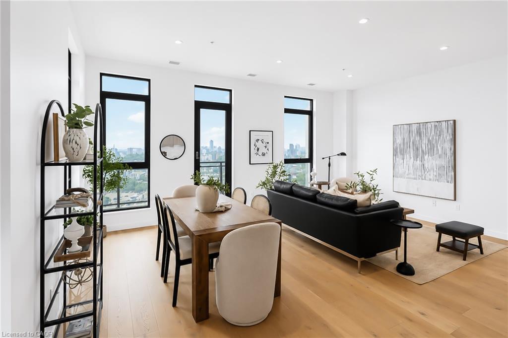 Furnished condo living and dining room with city views through tall windows.