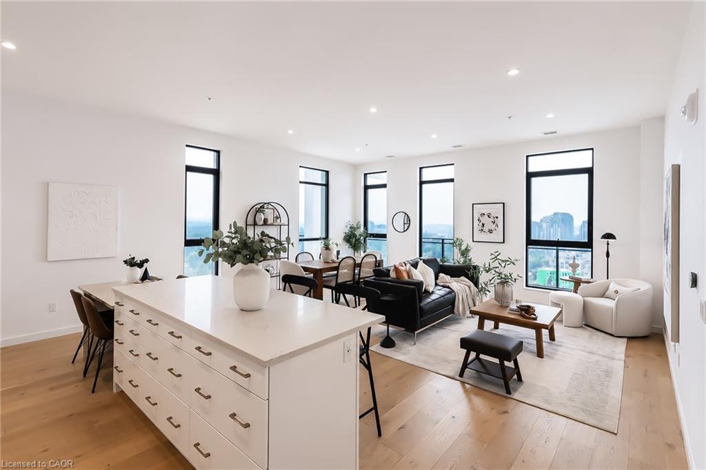Open-plan condo kitchen and living room with a large island and city-view windows.