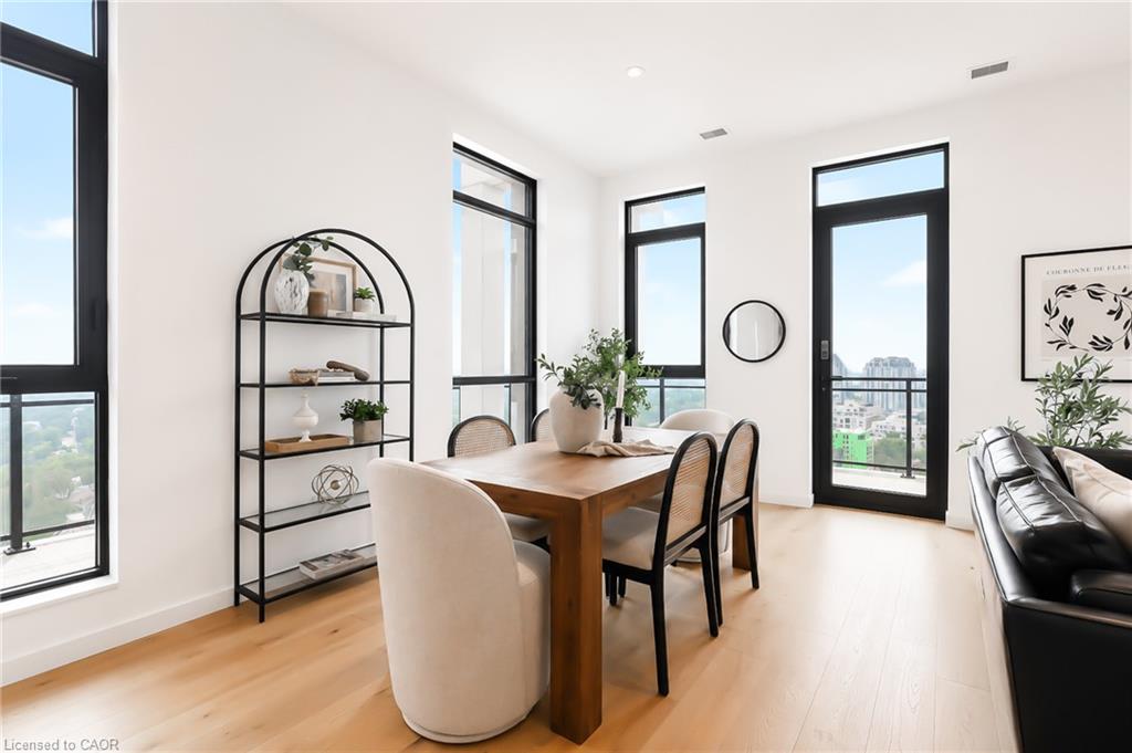 Condo dining area with a wooden table and floor-to-ceiling windows overlooking the city.