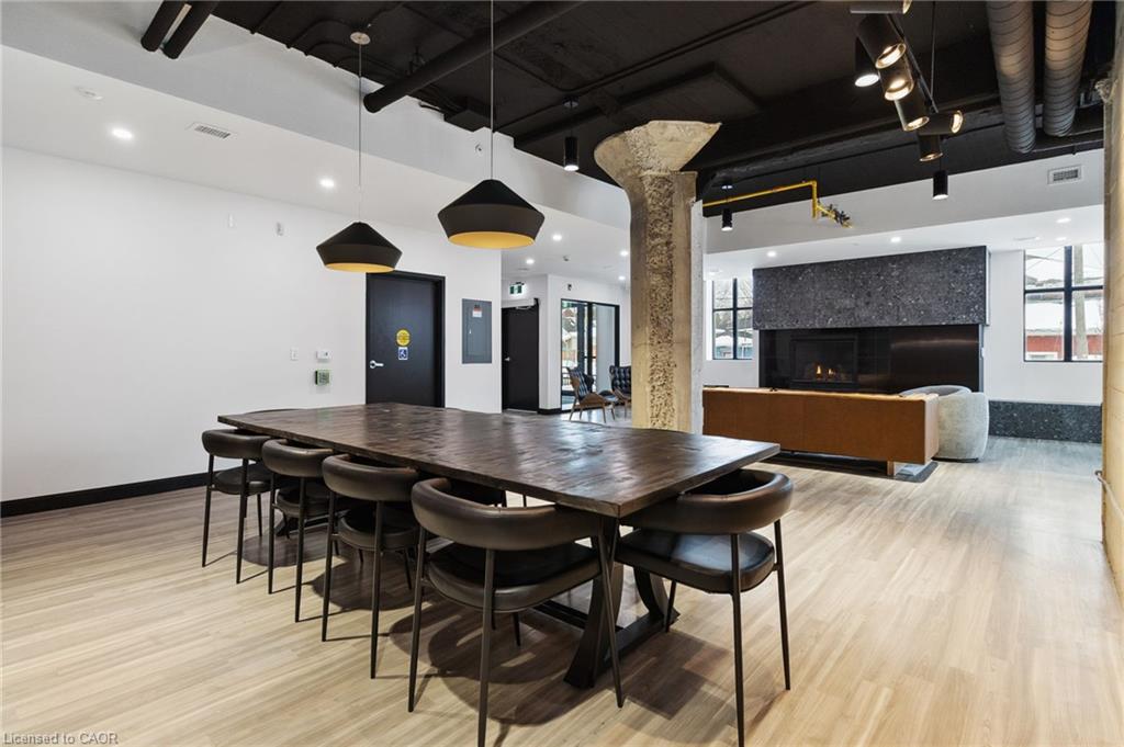 Furnished communal lounge with a long dining table, leather chairs, and a fireplace.