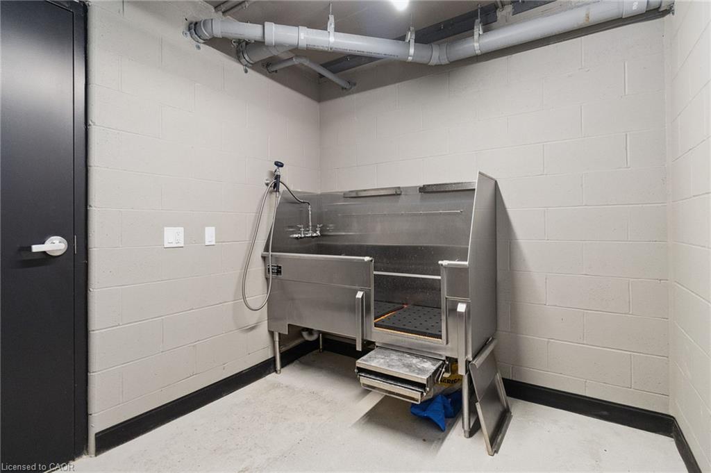 Stainless-steel pet washing tub in a tiled utility room.