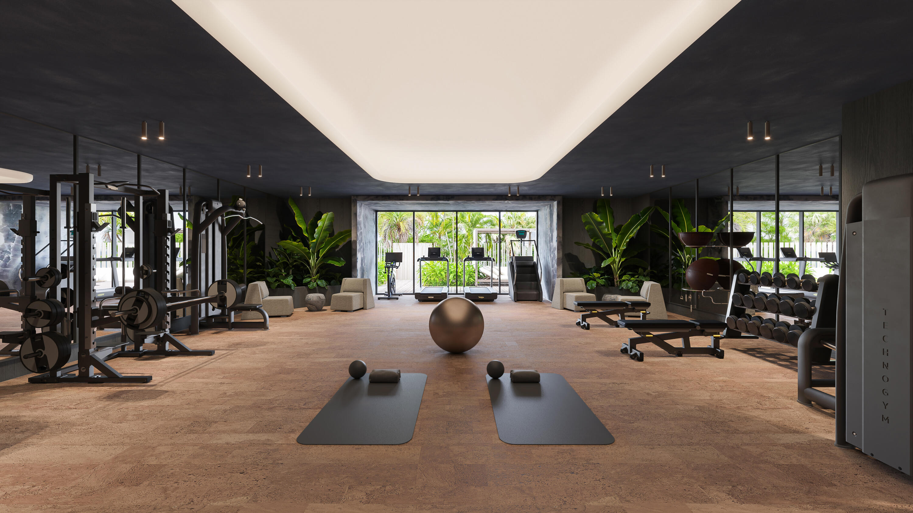 Fitness center with mirrored walls, exercise equipment, and windows overlooking tropical greenery.