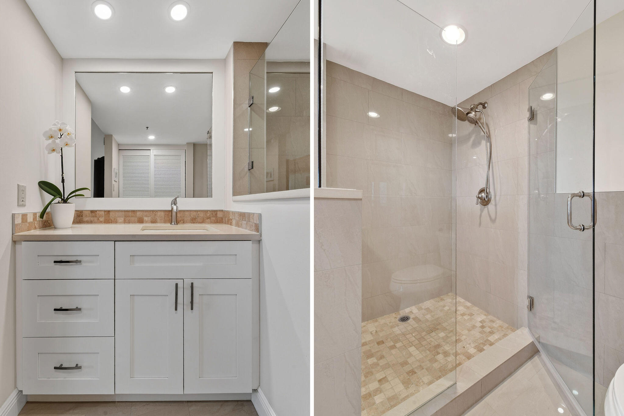 Bathroom vanity with an orchid beside a glass-enclosed tiled walk-in shower.