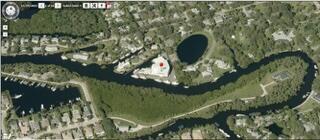 Aerial view of a river winding past residential neighborhoods and a green peninsula.
