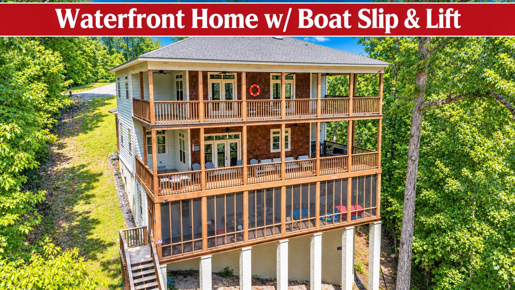 Waterfront home with broad wooden balconies and a screened porch, surrounded by trees.