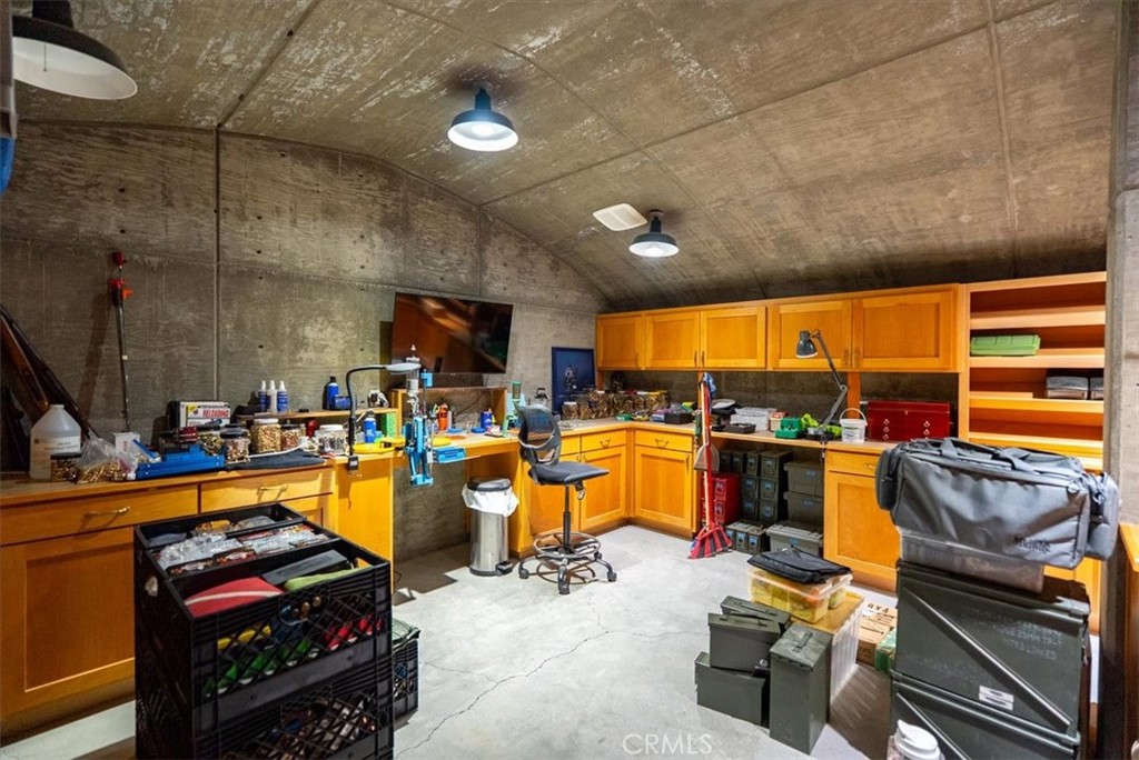 Workshop with orange cabinets, work counters, open shelves, and storage containers.