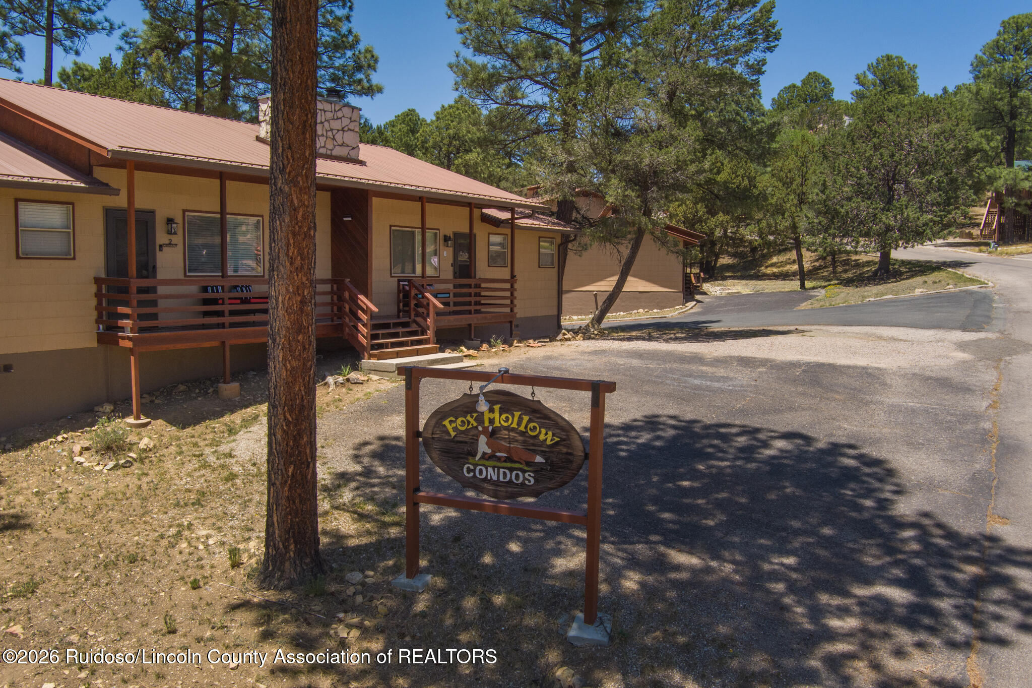 Fox Hollow Condos building with covered porches and an entrance sign.