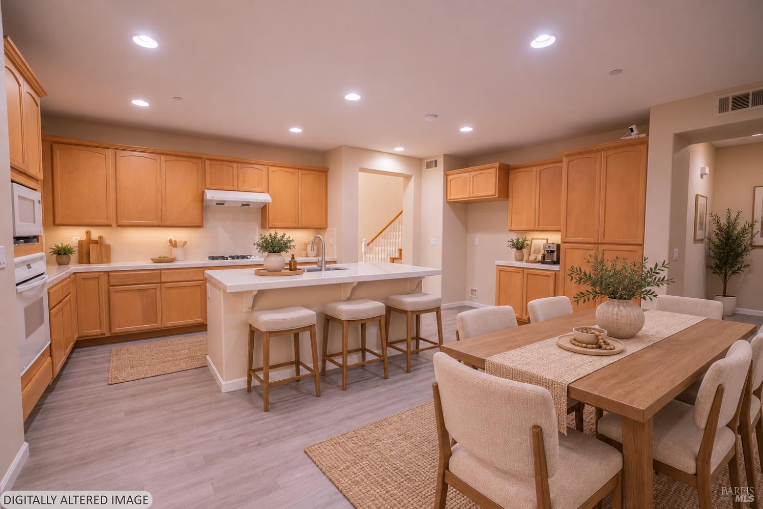 Open kitchen and dining area with wood cabinetry, a large island, and a long dining table.