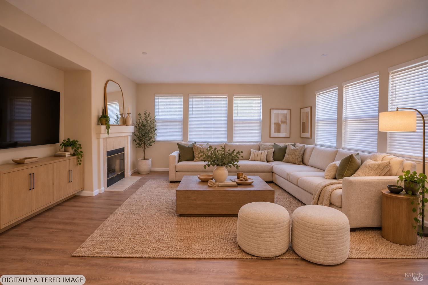 Staged living room with a fireplace, large sectional sofa, and windows with white blinds.