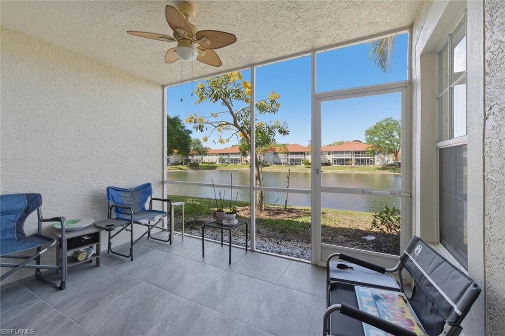 Screened lanai with tiled floor and patio chairs overlooking the water.