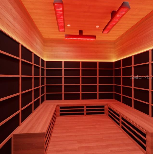 Cedar-lined sauna with tiered benches and red overhead heating panels.