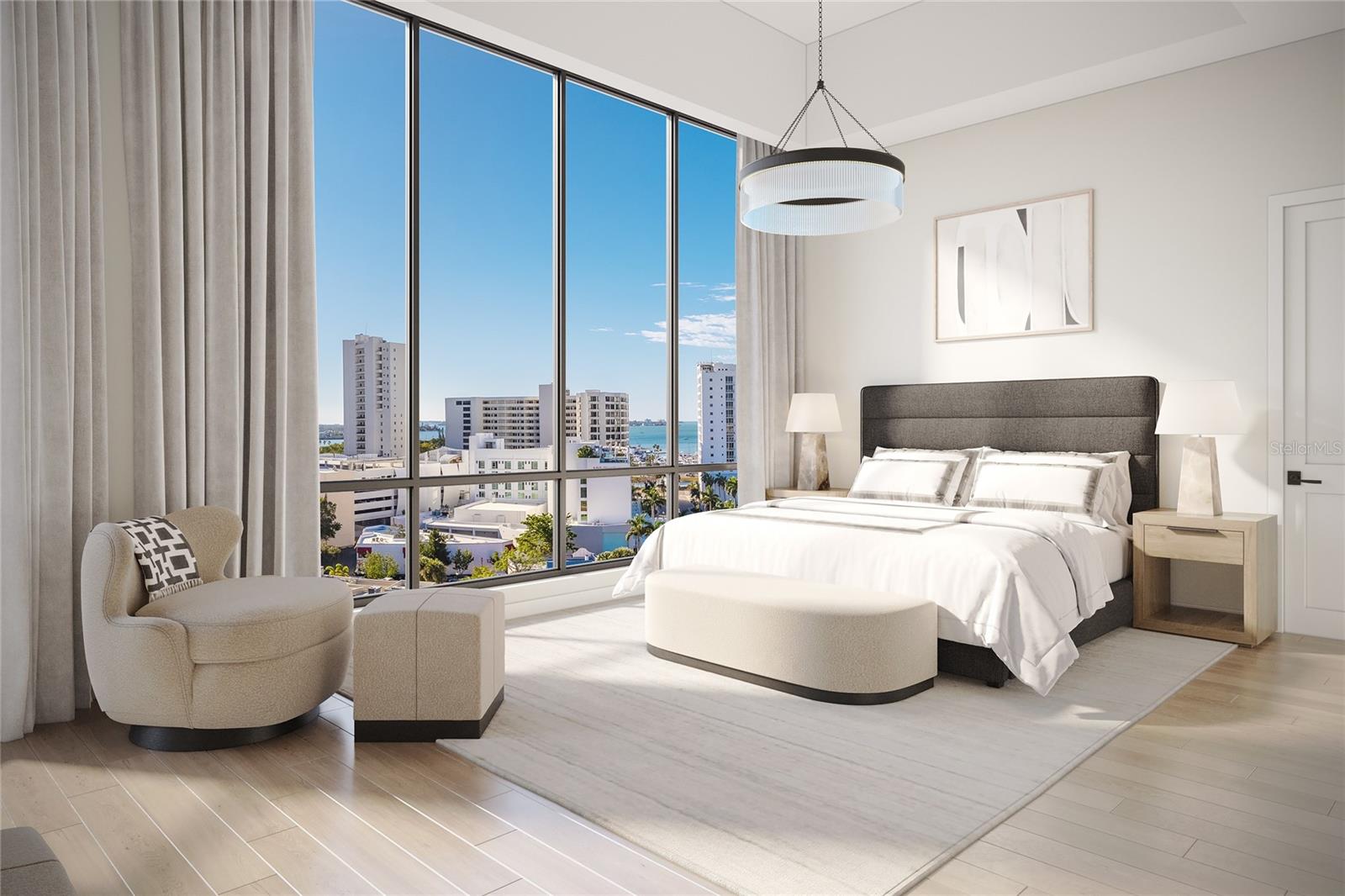 Staged bedroom with floor-to-ceiling windows overlooking city buildings and water.