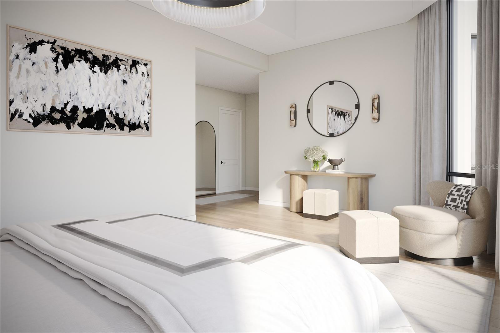 Furnished bedroom with a white bed, abstract artwork, and a curved chair beside tall windows.