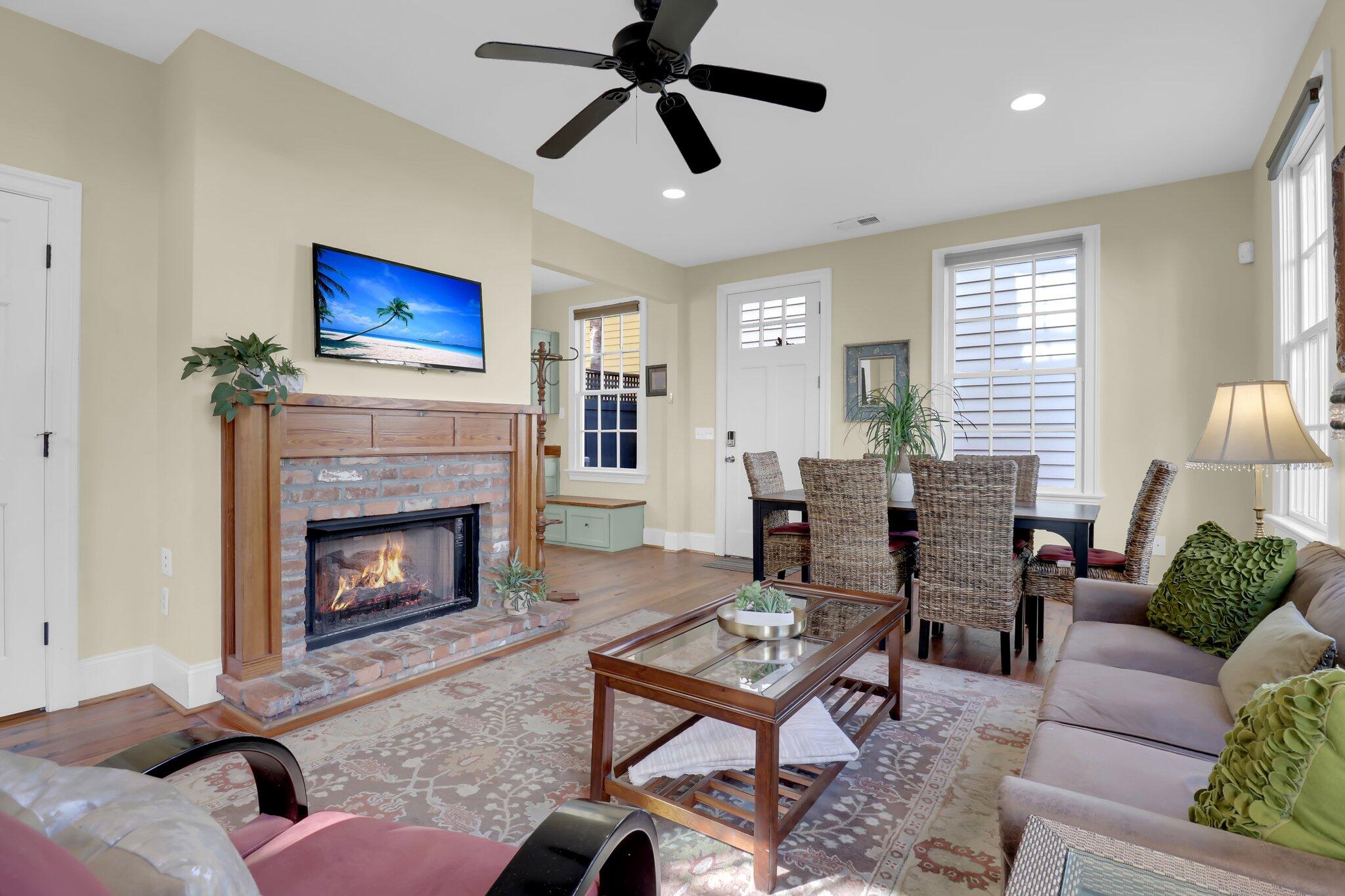 Living room with a brick fireplace, glass-top coffee table, and adjoining dining area.