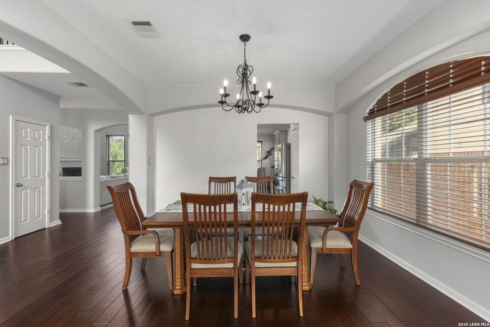 Dining room with a dark wood table, matching chairs, and a black chandelier.