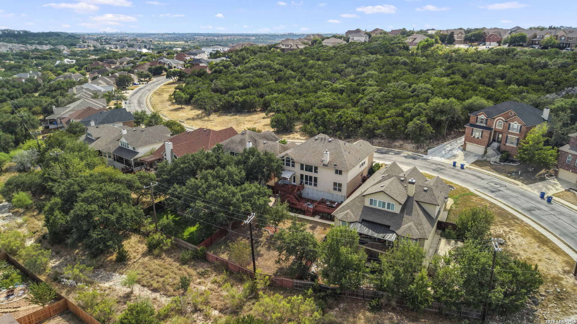 Aerial view of homes along a wooded greenbelt in a San Antonio neighborhood.