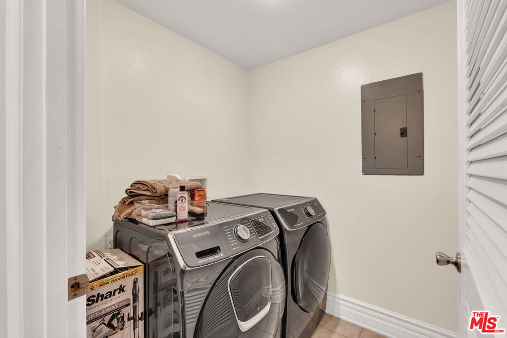 Laundry room with a gray Samsung washer and dryer and folded towels.