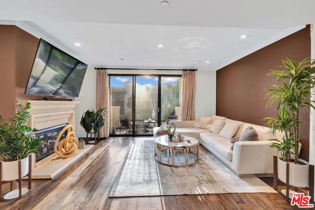 Living room with a white sectional, fireplace, and sliding glass doors opening to a balcony.