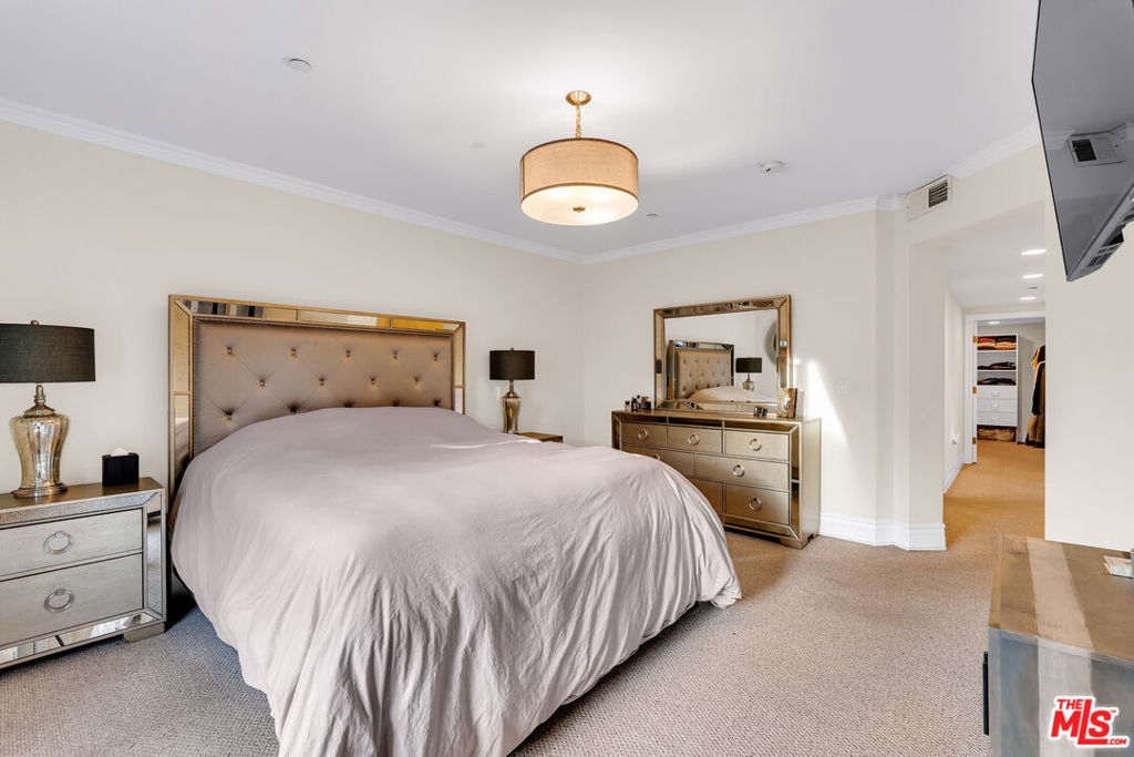 Furnished bedroom with a large mirrored-headboard bed and matching mirrored dresser.