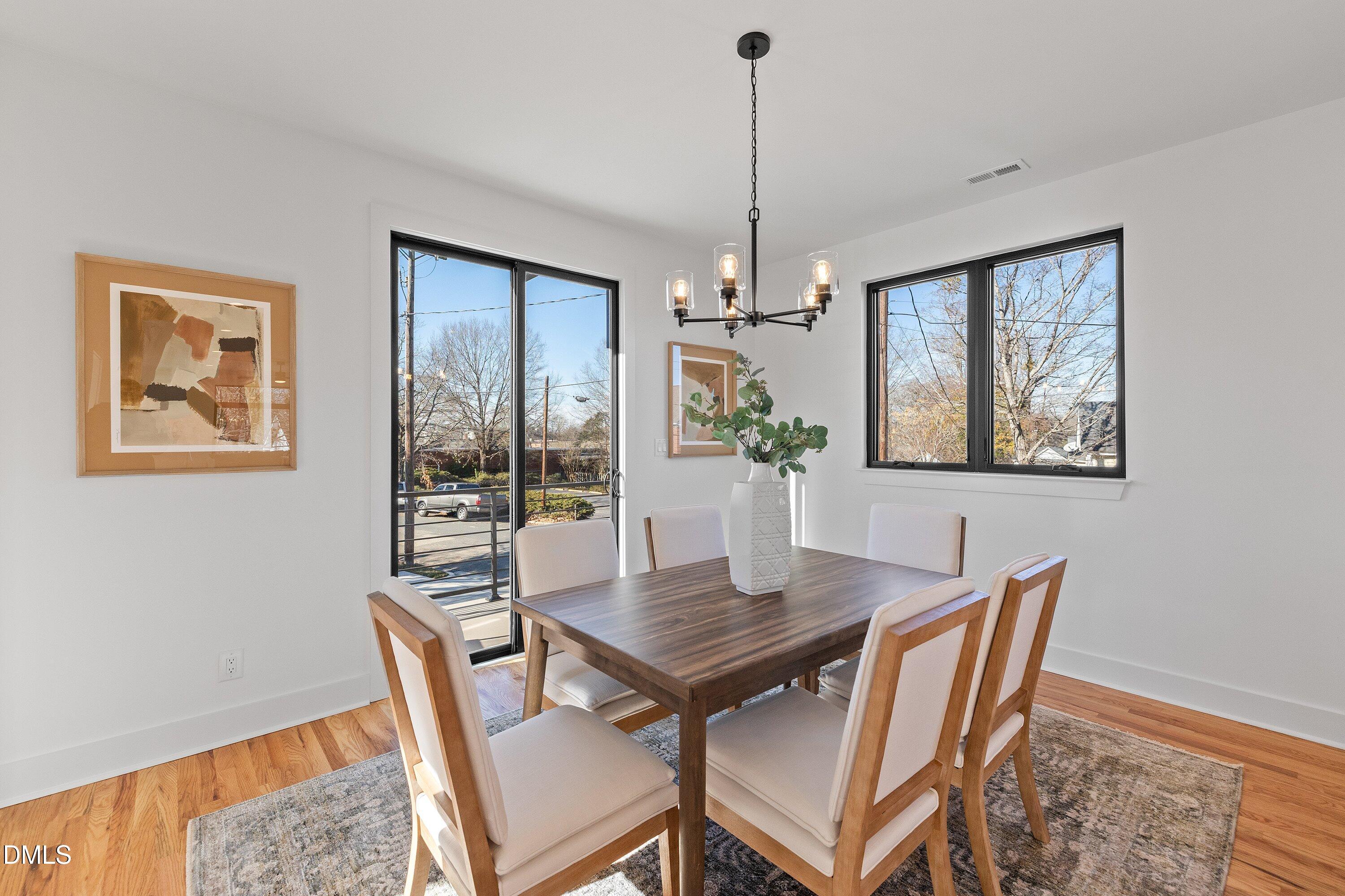 Furnished dining room with a dark wood table, upholstered chairs, and large windows.
