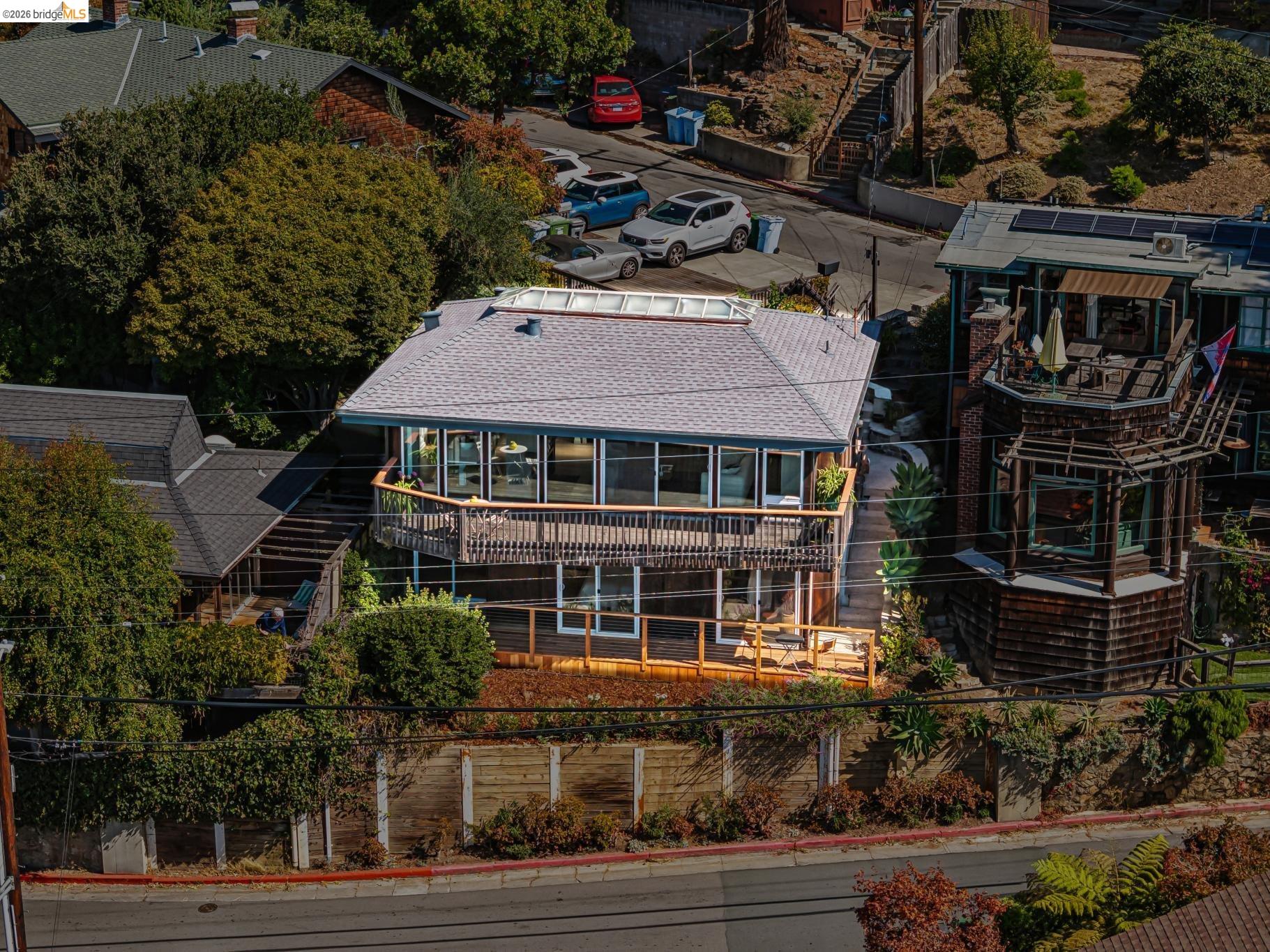 Modern multi-level home with broad glass windows, wraparound balconies, and a rooftop skylight.