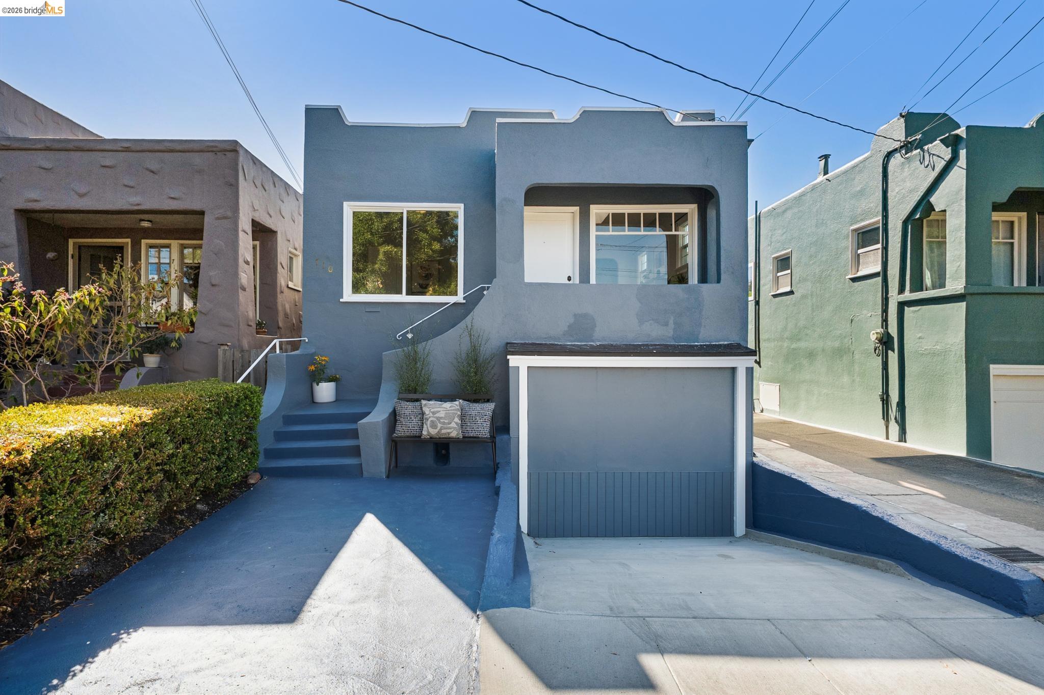 Blue-gray home with a raised entry, front steps, and a driveway.