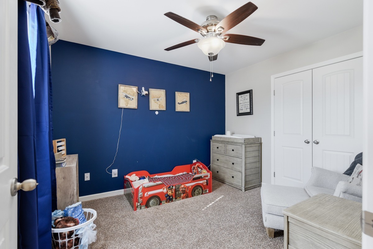 Child’s bedroom with a blue accent wall and red character-themed toddler bed.