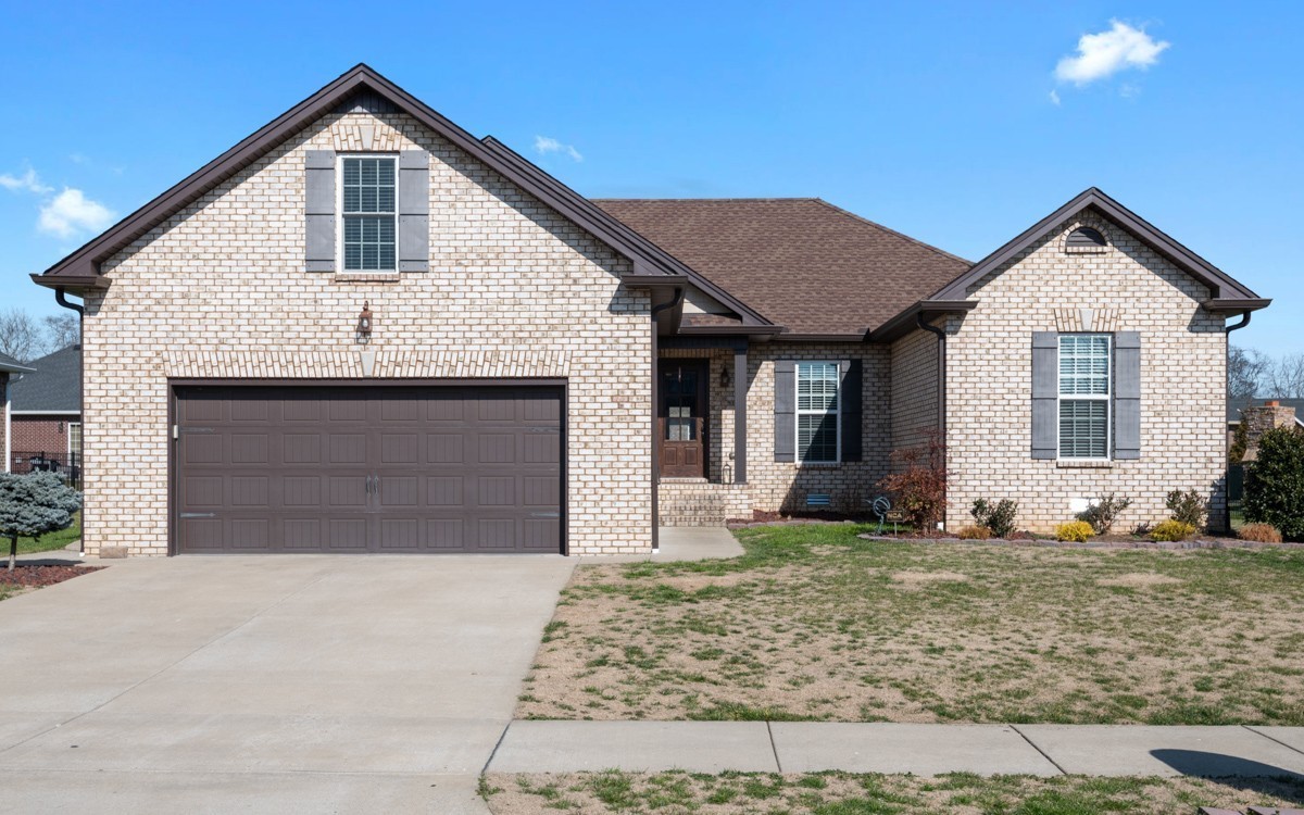 Brick house with a two-car garage, multiple gables, and a broad concrete driveway.
