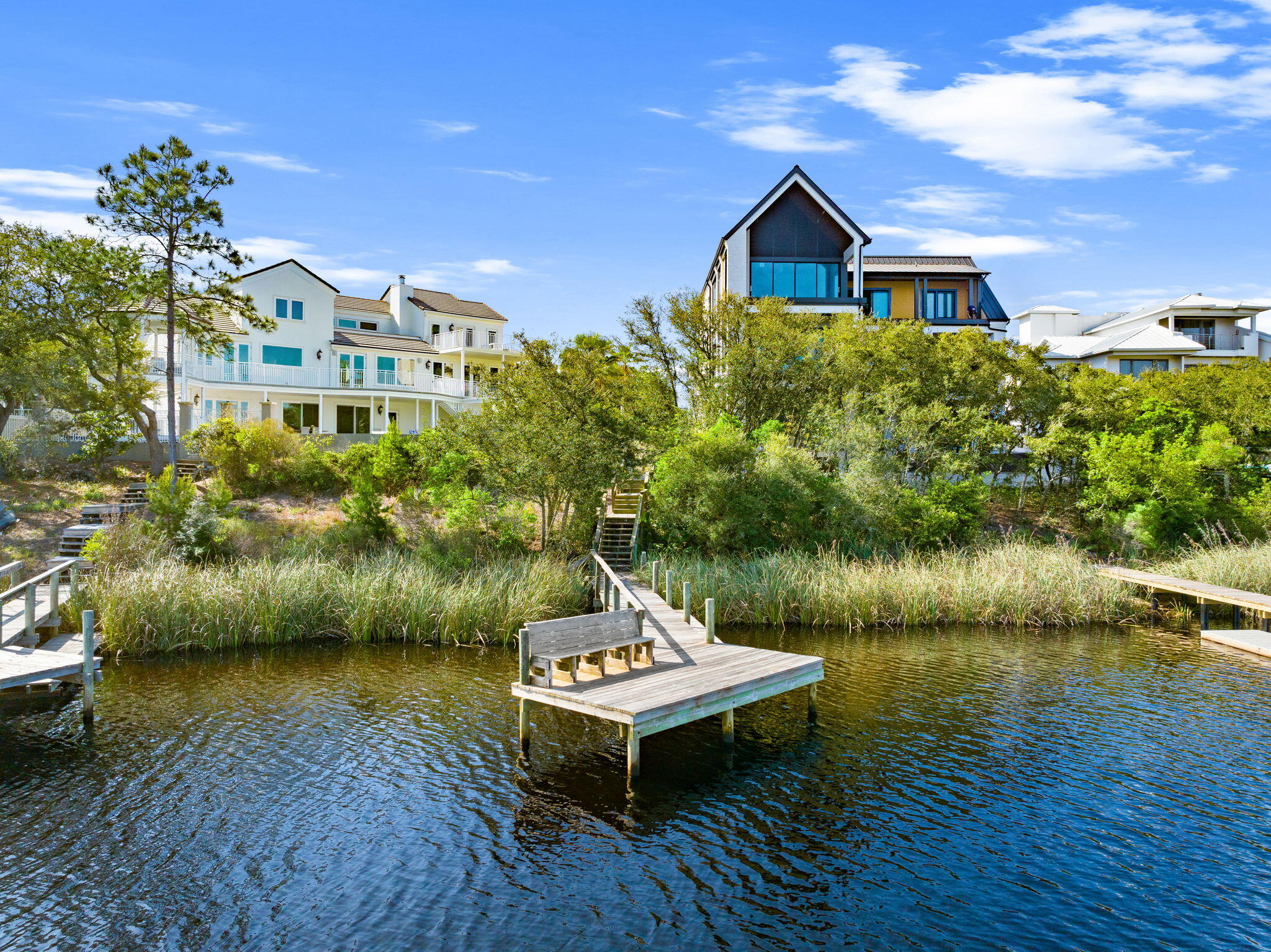 Waterfront homes and wooden docks along a calm inlet.