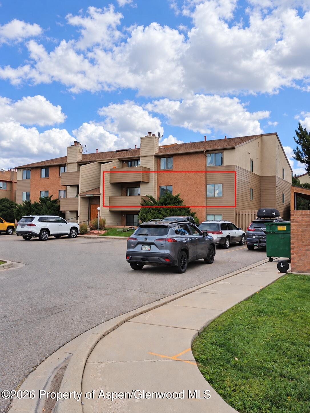 Condominium building exterior with the featured unit outlined in red.