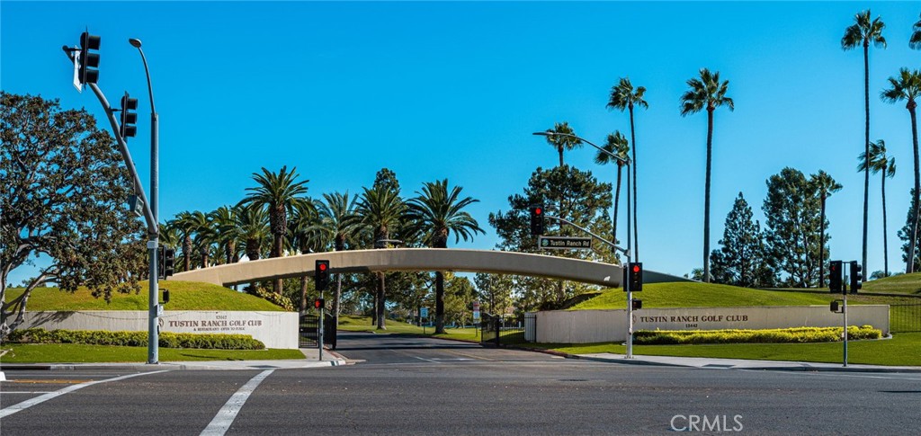 Tustin Ranch Golf Club entrance with a curved archway, palm trees, and landscaped lawns.