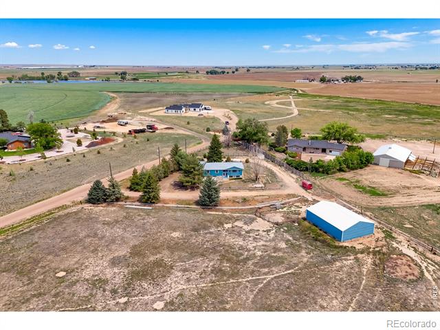 Rural acreage with several homes, outbuildings, dirt drives, and surrounding farmland.