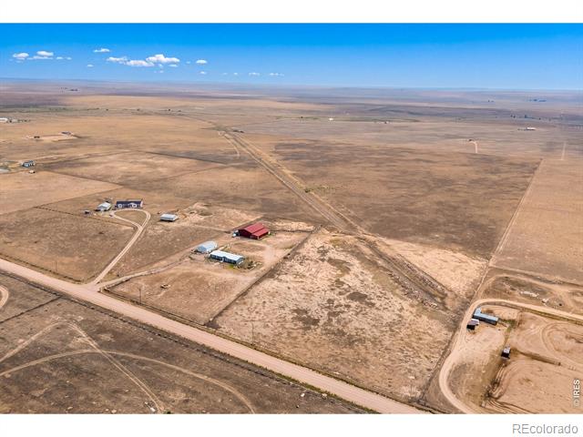 Aerial view of a rural property with scattered buildings and roads across open plains.